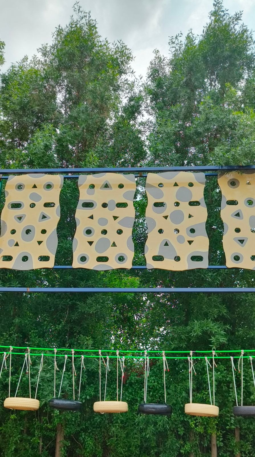 Climbing wall and tyre swings in the adventure park